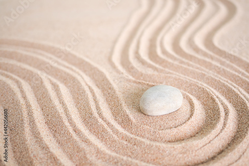 Japanese zen garden stone on wave sand beach. rock or pebbles with copy space. for aroma therapy spa on summer holidays. meditation wellness and tranquility Japanese concept.