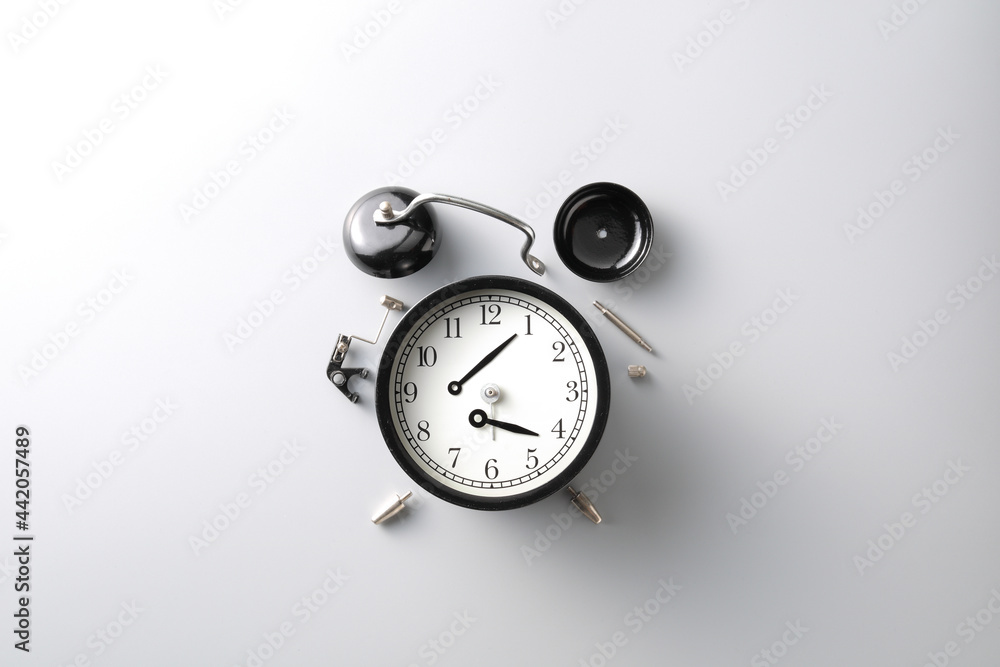 broken black alarm clock on grey background with copy space , time and wilted concept broken black alarm clock on grey background with copy space , time and wilted concept