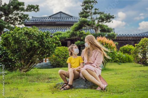Photography Mother and son travelers in medical mask looking at the Japanese traditional building