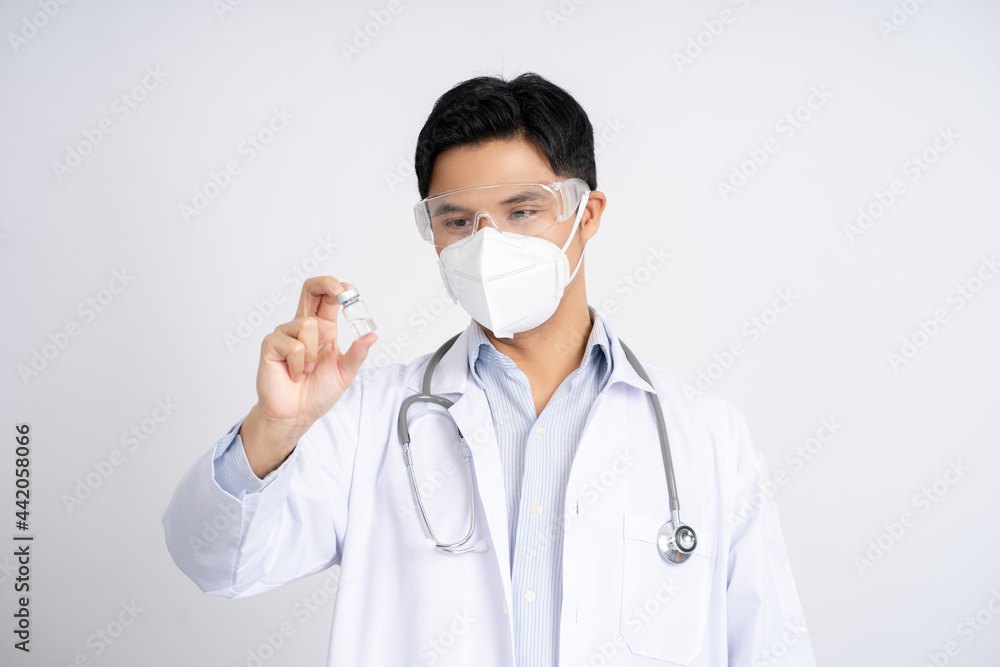 Medical care concept. Asian doctor or scientist in uniform with stethoscope and protective mask in laboratory looking at medicine bottle. He held a bottle of vaccine in his hand. Medical care concept. Asian doctor or scientist in uniform with stethoscope and protective mask in laboratory looking at medicine bottle. He held a bottle of vaccine in his hand.