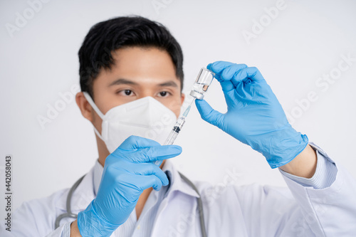 Doctor  nurse or scientist wears blue nitrile gloves. He holds the coronavirus vaccine  vaccination against the epidemic.