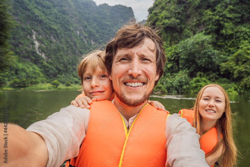 Happy family tourists in Trang An Scenic Landscape Complex in Ninh Binh Province, Vietnam A UNESCO World Heritage Site. Resumption of tourism in Vietnam after quarantine Coronovirus COVID 19
