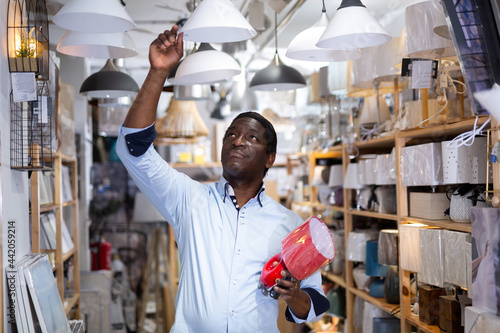 Man chooses a table lamp in an electrical store