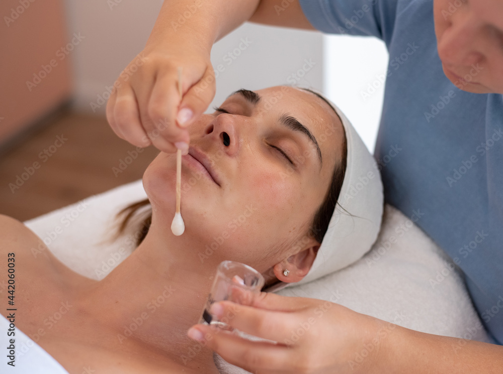 Cleaning and moisturise nourish skin of face. Cosmetologist put special lotion on face by applicator. Beautiful woman receiving facial peeling. Treatment skin care in cosmetology beauty spa salon. Cleaning and moisturise nourish skin of face. Cosmetologist put special lotion on face by applicator. Beautiful woman receiving facial peeling. Treatment skin care in cosmetology beauty spa salon.