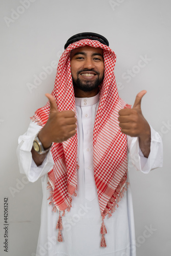 Canvas Print an arabian young man in a turban smiling while standing looking at the camera wi