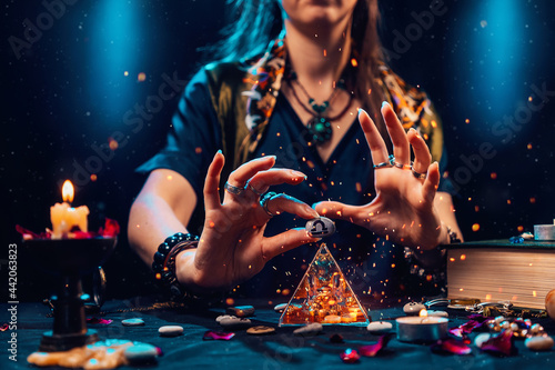 Astrology and horoscope. A witch holds a stone with the sign of the zodiac Libra. Close up. The concept of divination and magic photo