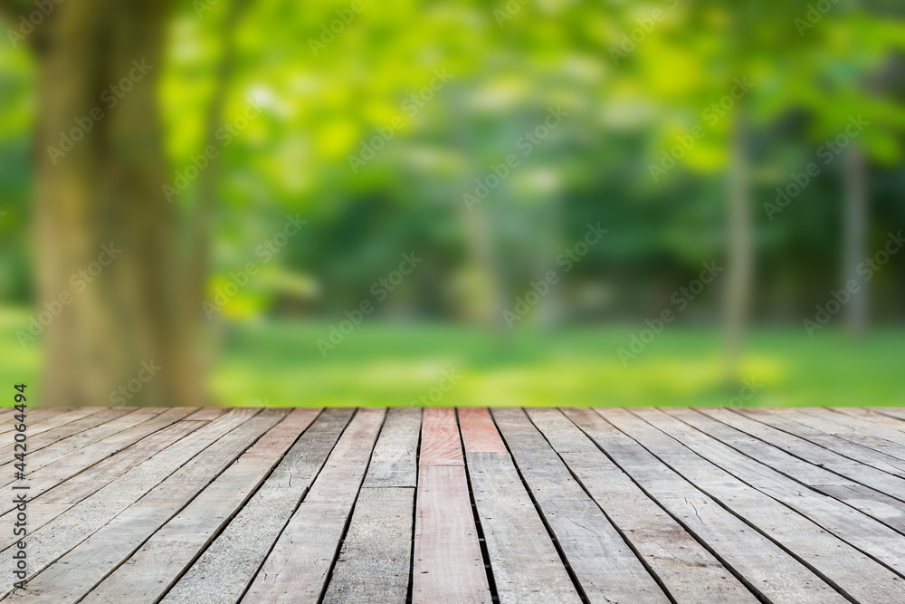 Wood floor with blurred trees of nature park background and summer season, product display montage Wood floor with blurred trees of nature park background and summer season, product display montage
