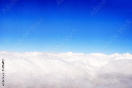 Aerial view from the aircraft to clouds in the blue sky