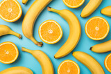 Top view photo of scattered unpeeled bananas and cut oranges on isolated pastel blue background