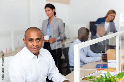 positive latino male manager in white office photo