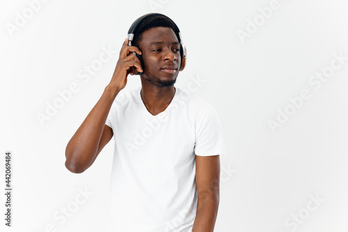 man of african appearance in white t-shirt wearing headphones music technology lifestyle
