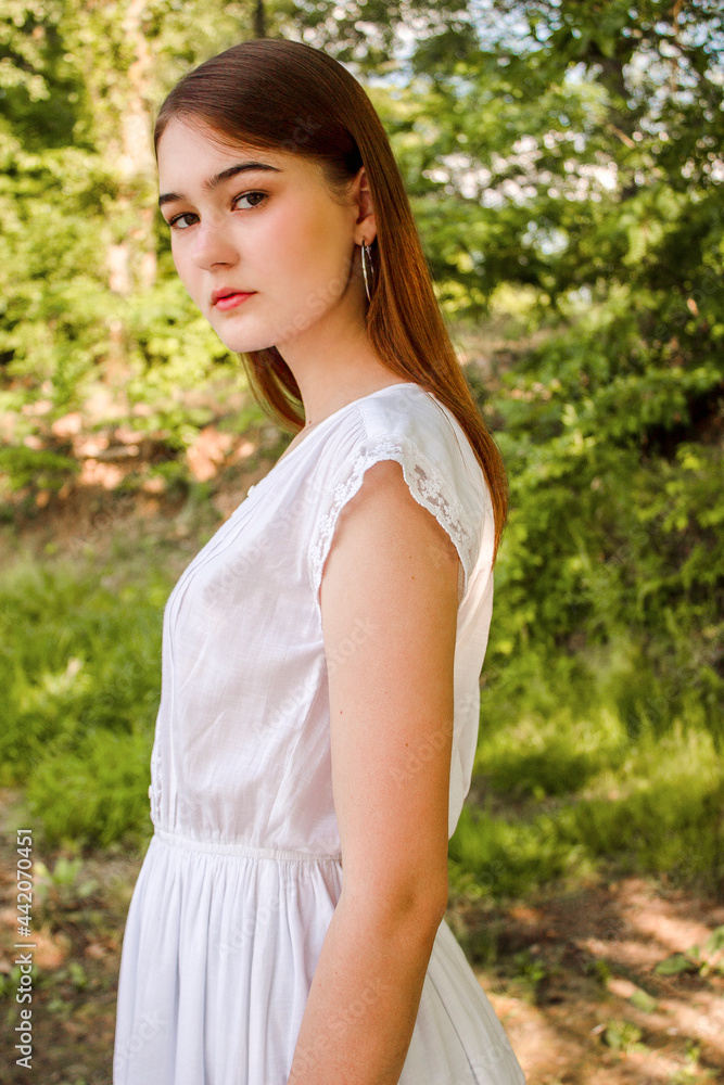 Portrait of a perfect girl in a park or in nature. Beautiful shape of body. Lovely girl's face. Green background. Expressive look. Girl's glance. White beautiful model Portrait of a perfect girl in a park or in nature. Beautiful shape of body. Lovely girl's face. Green background. Expressive look. Girl's glance. White beautiful model