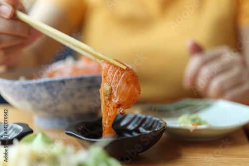 Canvastavla Salmon sashimi in chopsticks dipping with soy sauce