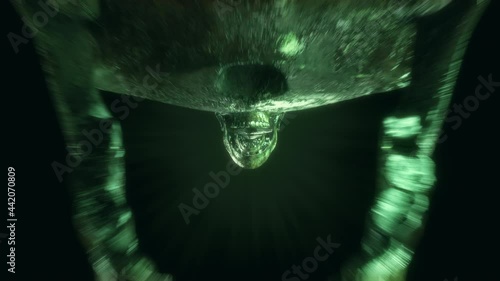 4K Skull Seamless animation horror loop of a realistic skeleton head opening jaw skeletons heads in the cemetary dark tunnel. Scary halloween background VJ loop