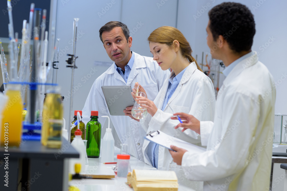 group of researchers during work on devices in laboratory group of researchers during work on devices in laboratory