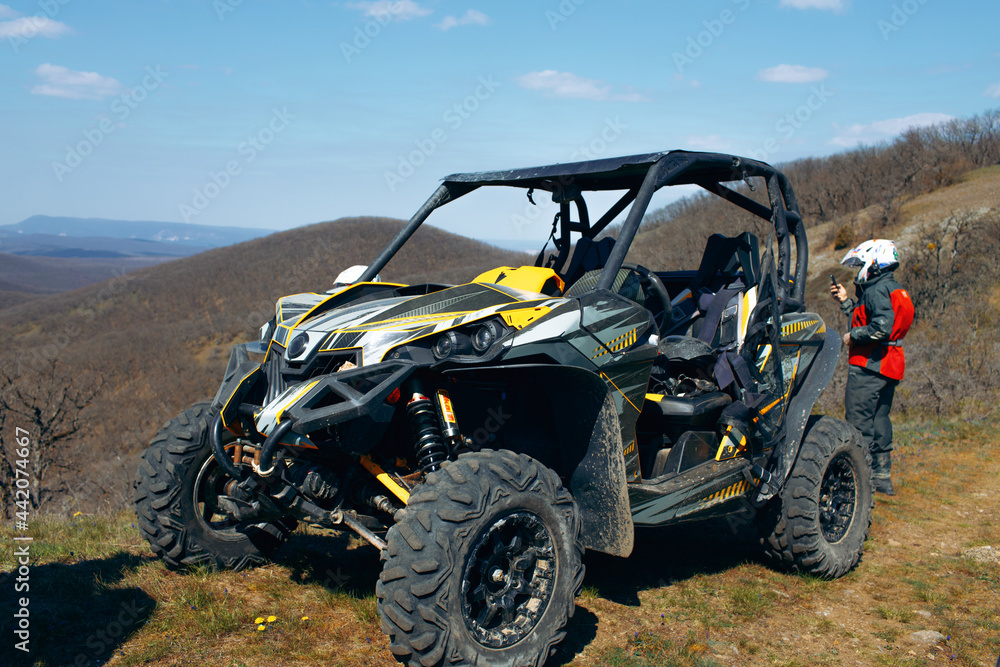 Buggy parked in mountains and driver in sport equipment standing behind  Stock 写真 | Adobe Stock