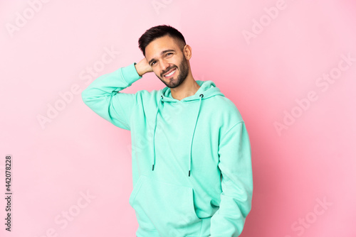 Young caucasian man isolated on pink background having doubts while scratching head © luismolinero