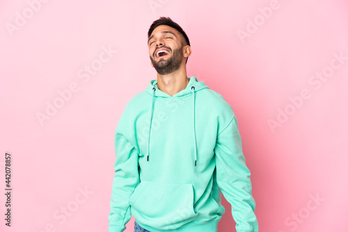 Young caucasian man isolated on pink background laughing © luismolinero
