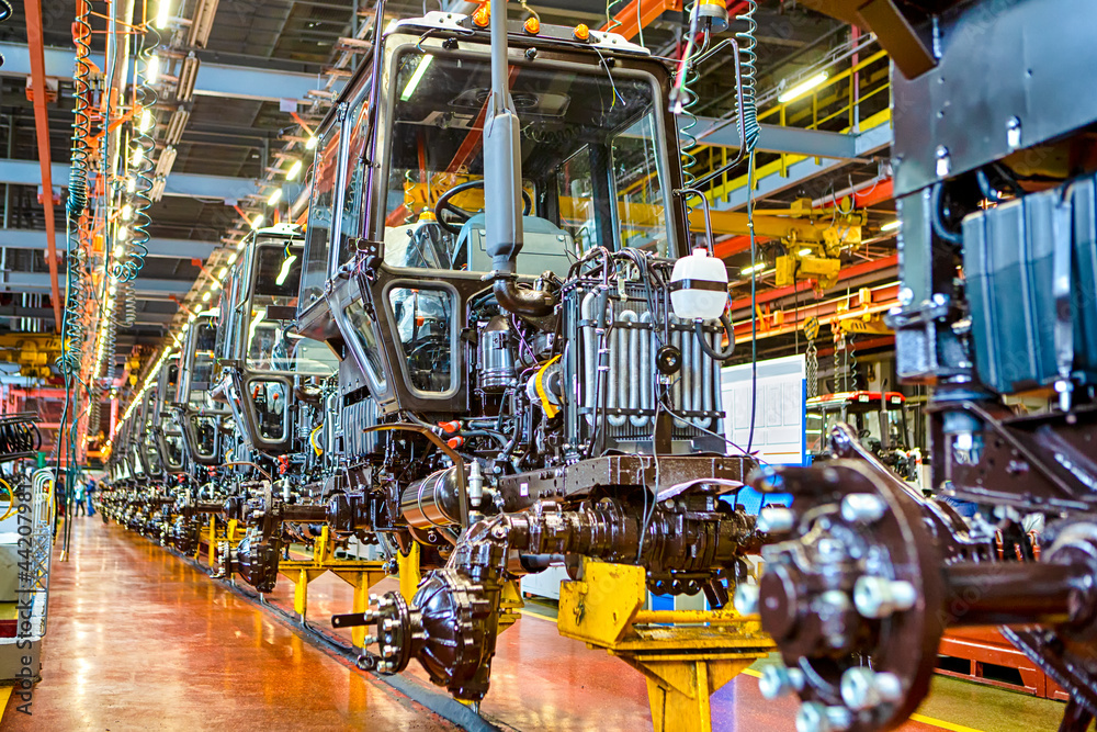Industry and Manufacturing Concepts. Modern Tractors Machinery Assembly Line With Manufacturing Facilities Alongside.