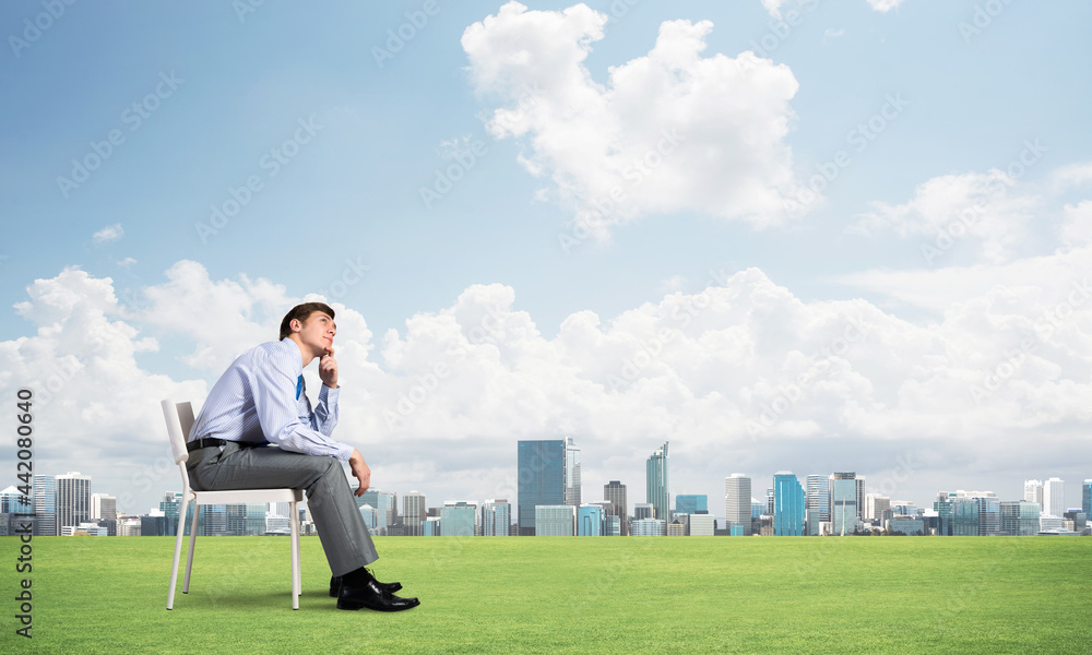 Young businessman sitting on an office chair Young businessman sitting on an office chair