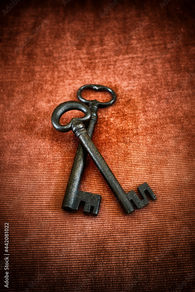 Old medieval wrought iron keys on red background Old medieval wrought iron keys on red background
