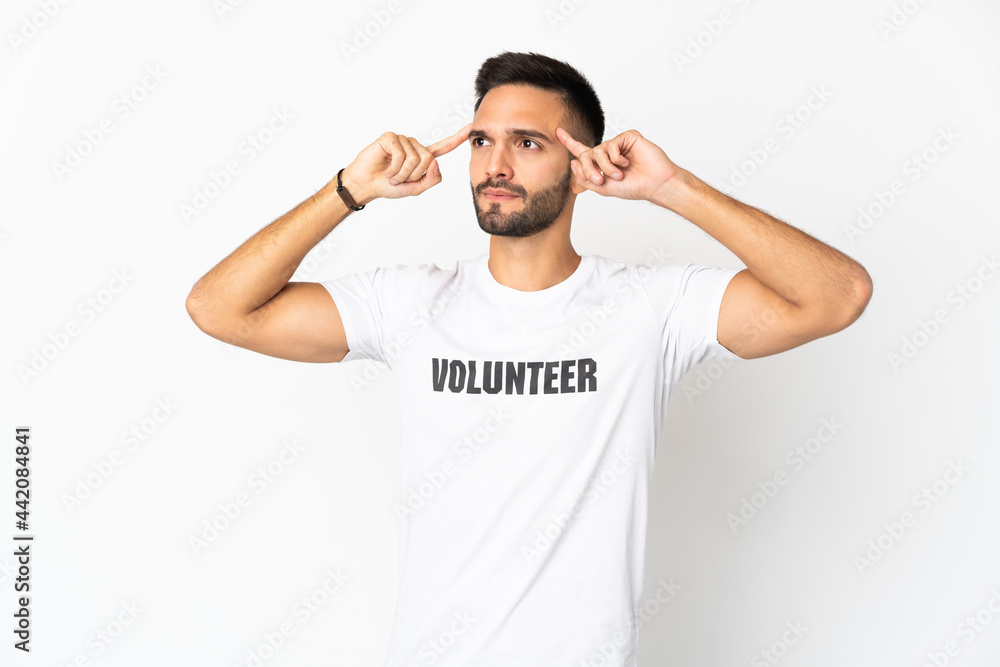 Young caucasian volunteer man isolated on white background having doubts and thinking Young caucasian volunteer man isolated on white background having doubts and thinking