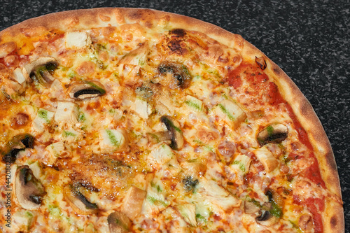 Delicious pizza with chicken, mushrooms and cheese