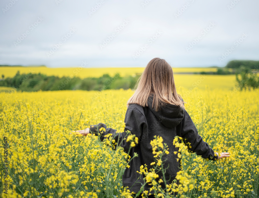 Fototapeta premium Young girl on yellow rapeseed field