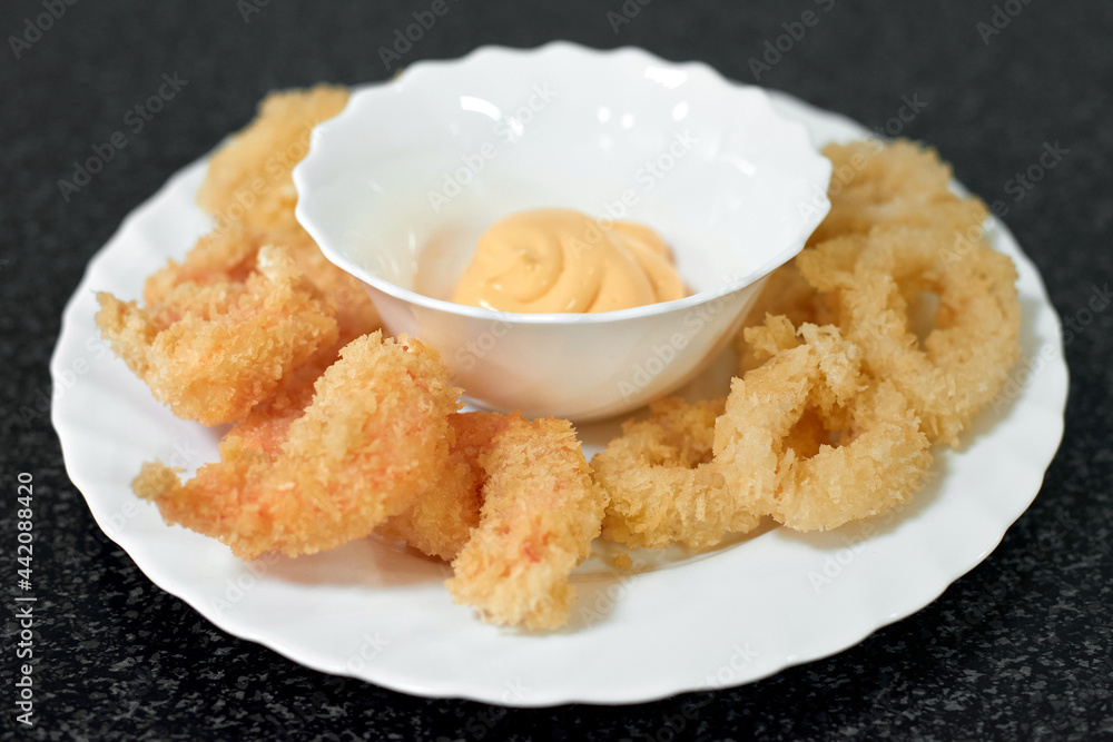 Squid rings and shrimps fried in batter with cheese sauce. Seafood appetizer Squid rings and shrimps fried in batter with cheese sauce. Seafood appetizer