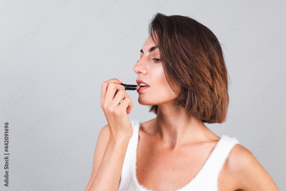 Close beauty portrait of woman with makeup and brown lipstick on gray background Close beauty portrait of woman with makeup and brown lipstick on gray background