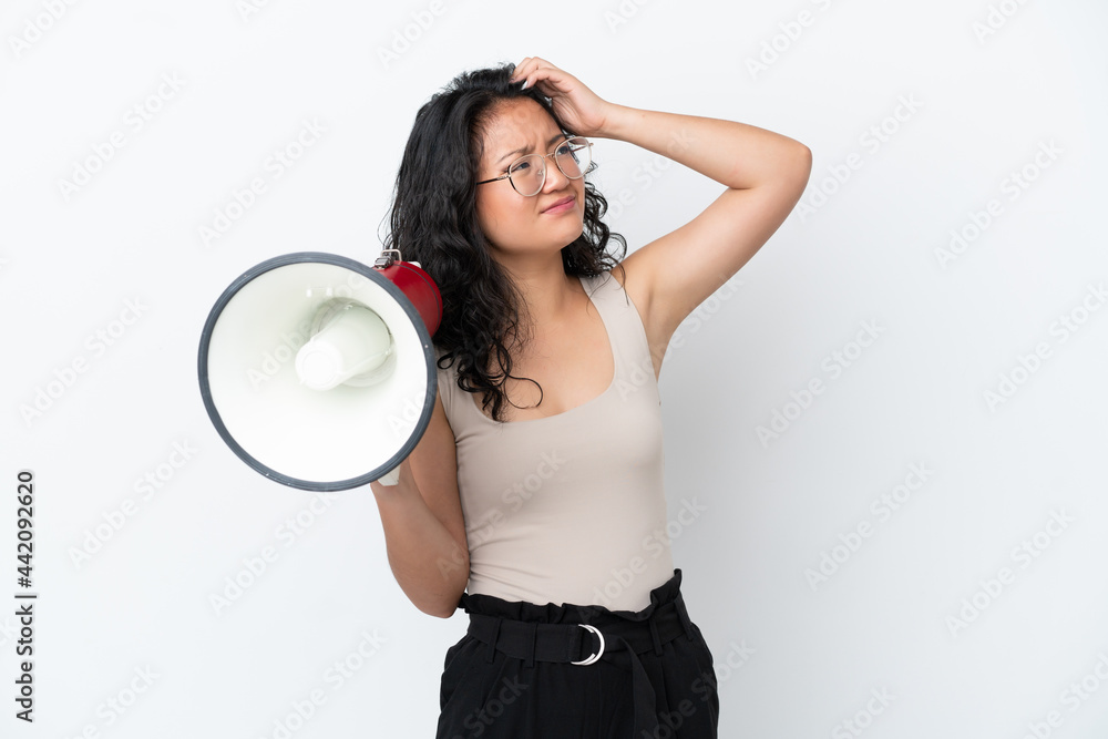 Young asian woman isolated on white background holding a megaphone and having doubts Young asian woman isolated on white background holding a megaphone and having doubts