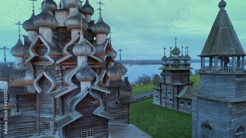 Aerial close details Kizhi monastery historical complex on island Karelia Russia unique traditional temple facade, domes. Cloudy fog dark. Peasant serfdom life traditions culture heritage photo