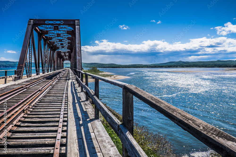 The Atlantic ocean and the rail track bridge  in Barachois, near Percé in Gaspesie, Quebec (Canada)