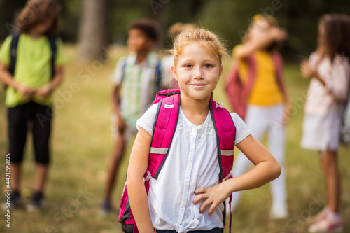 Kid wearing backpack in nature.