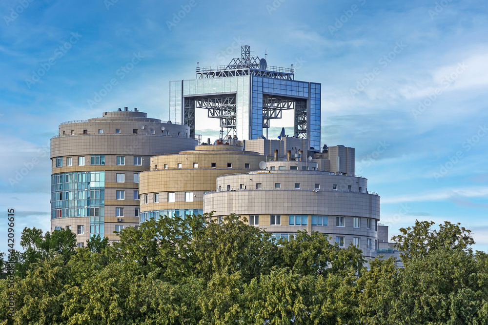The upper part of the complex of buildings on the background of a blue sky with white clouds The upper part of the complex of buildings on the background of a blue sky with white clouds