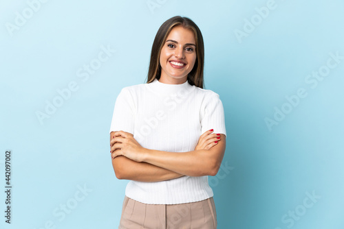 Young Uruguayan woman isolated on blue background keeping the arms crossed in frontal position