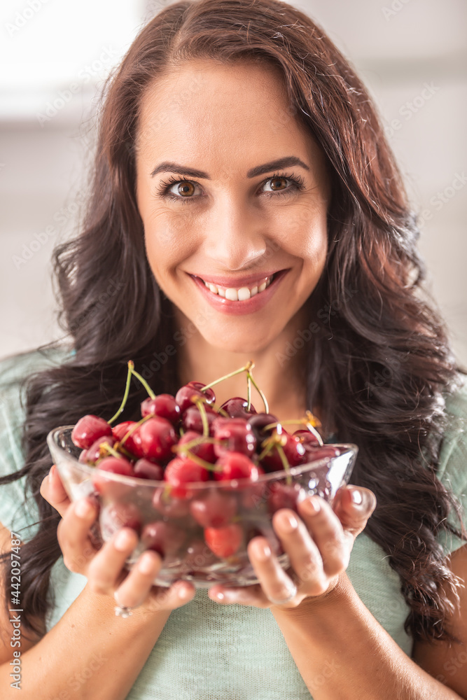 Beautiful woman holding glass bowl full of fres cherries Beautiful woman holding glass bowl full of fres cherries