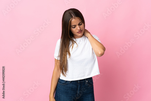 Young Uruguayan woman isolated on pink background with neckache