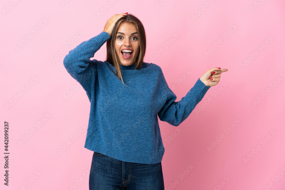 Young Uruguayan woman isolated on pink background surprised and pointing finger to the side Young Uruguayan woman isolated on pink background surprised and pointing finger to the side
