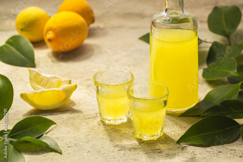 Close-up of italian lemon liqueur Limoncello. Hard light, stone background. photo