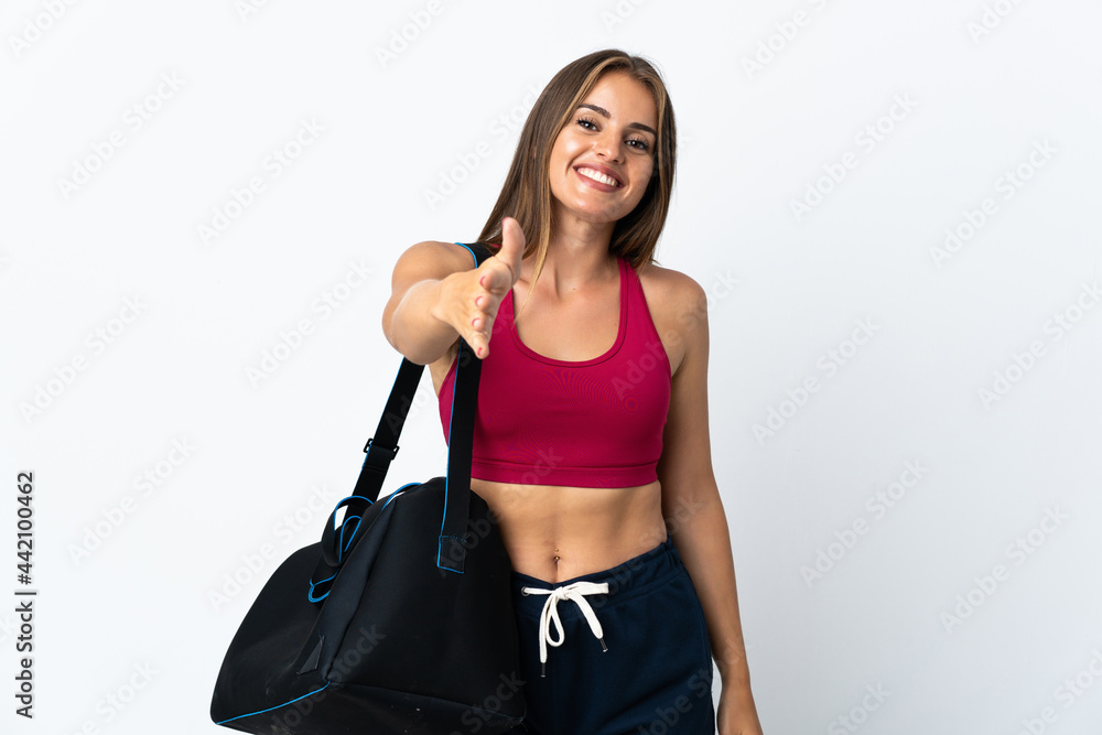 Young sport Uruguayan woman with sport bag isolated on white background shaking hands for closing a good deal Young sport Uruguayan woman with sport bag isolated on white background shaking hands for closing a good deal