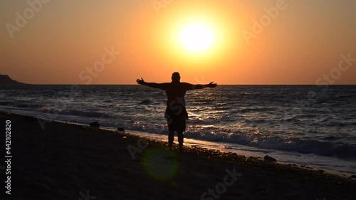 Back view, a man meets the dawn at sea. travel and vacation concept.