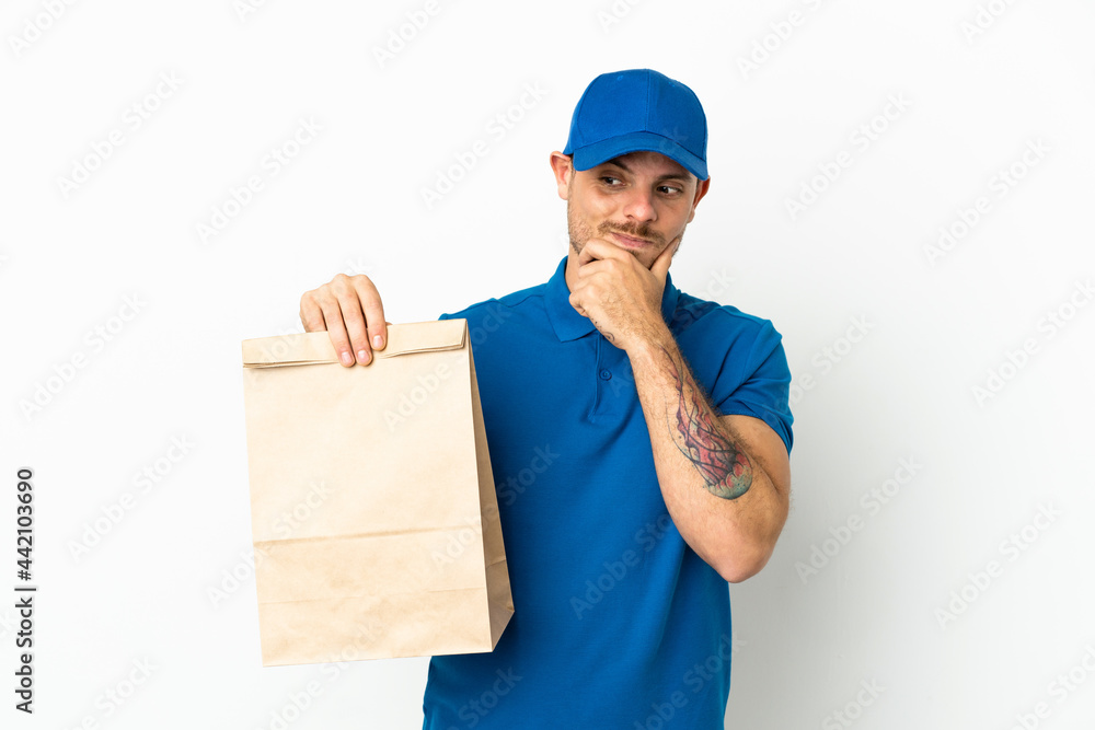 Brazilian taking a bag of takeaway food isolated on white background looking to the side and smiling Brazilian taking a bag of takeaway food isolated on white background looking to the side and smiling