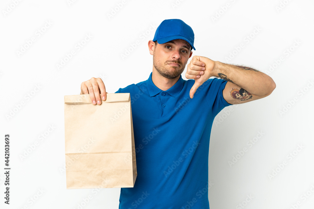 Brazilian taking a bag of takeaway food isolated on white background showing thumb down with negative expression Brazilian taking a bag of takeaway food isolated on white background showing thumb down with negative expression