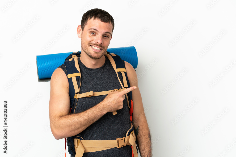 Brazilian mountaineer man with a big backpack over isolated white background pointing finger to the side Brazilian mountaineer man with a big backpack over isolated white background pointing finger to the side