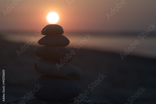 Balancing stones on top of each other. Sun at the top.