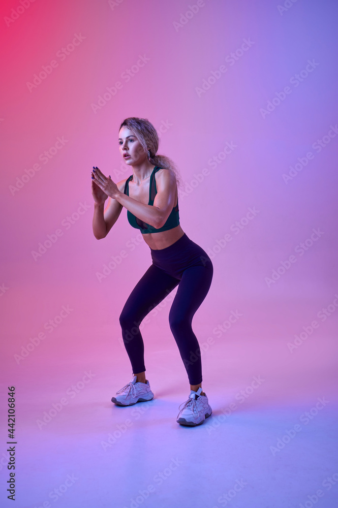 Slim female athlete doing exercise in studio Slim female athlete doing exercise in studio