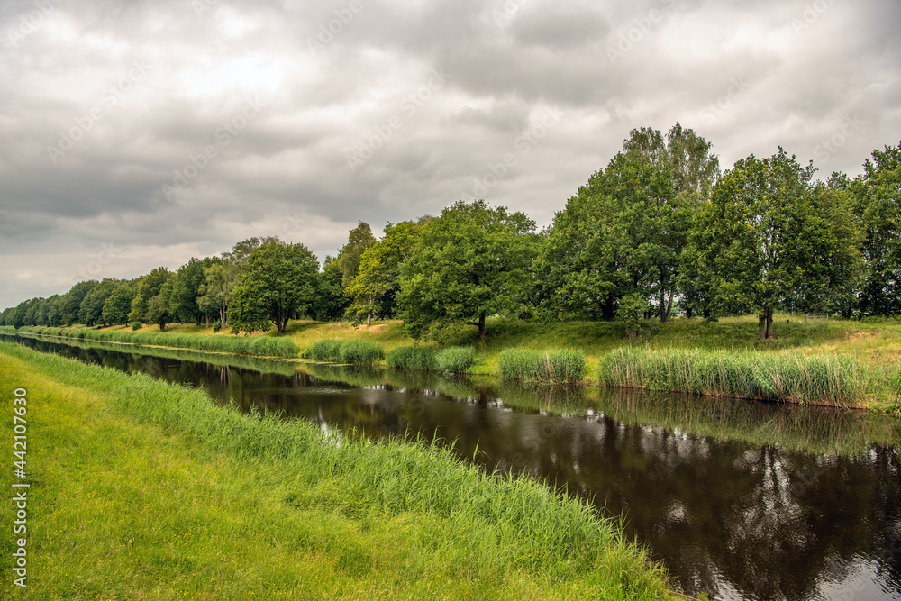 Dutch drainage canal on a cloudy and windless day in the beginning of the summer season. The photo was taken in the province of North Brabant.