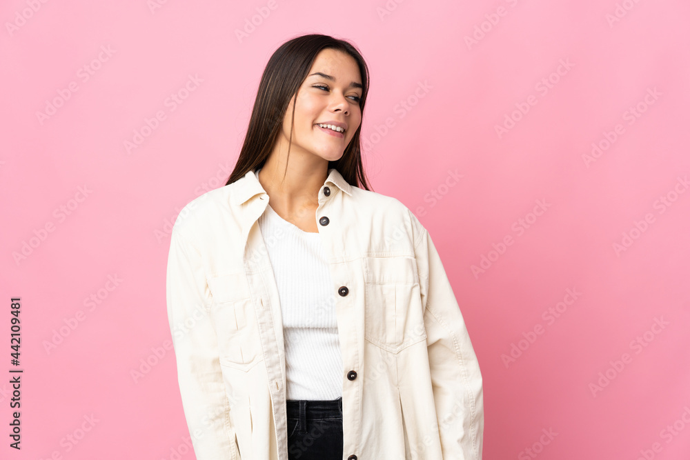 Teenager girl isolated on pink background looking side Teenager girl isolated on pink background looking side