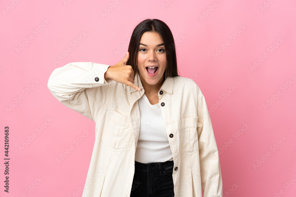 Teenager girl isolated on pink background making phone gesture. Call me back sign Teenager girl isolated on pink background making phone gesture. Call me back sign